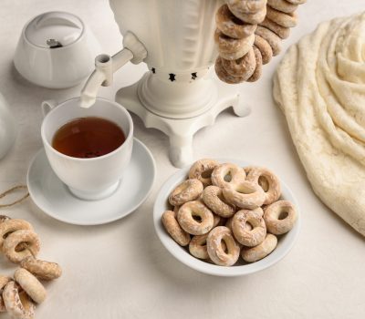a samovar with bagels and hot tea on the white tablecloth