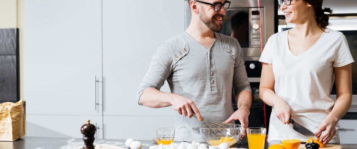 Young husband and wife preparing food for Valentine day