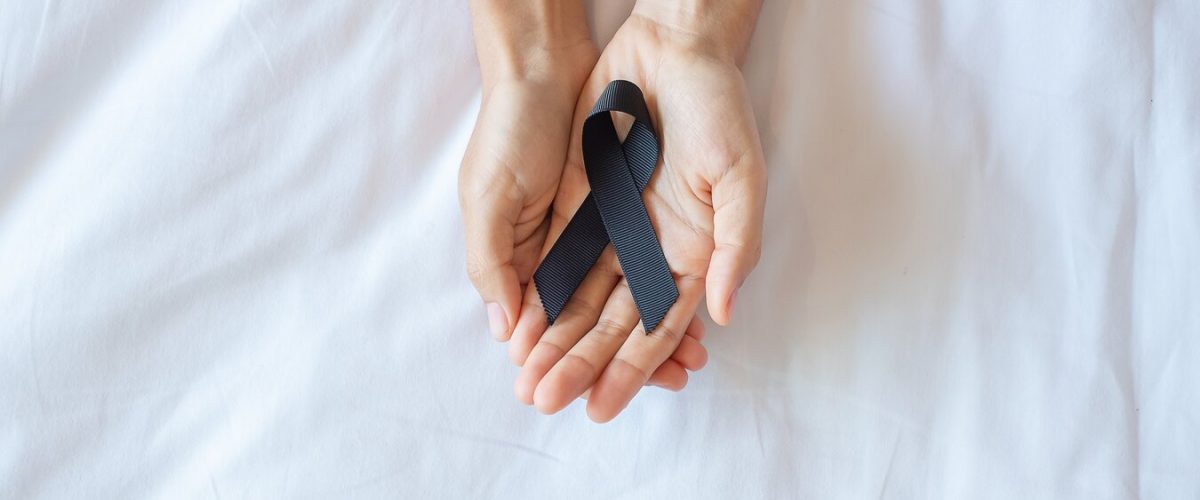 Melanoma and skin cancer, Vaccine injury awareness month and rest in peace concepts. Man holding black Ribbon on white bed background