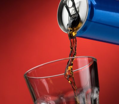 Pouring a refreshing sugary soft drink from a can into a glass